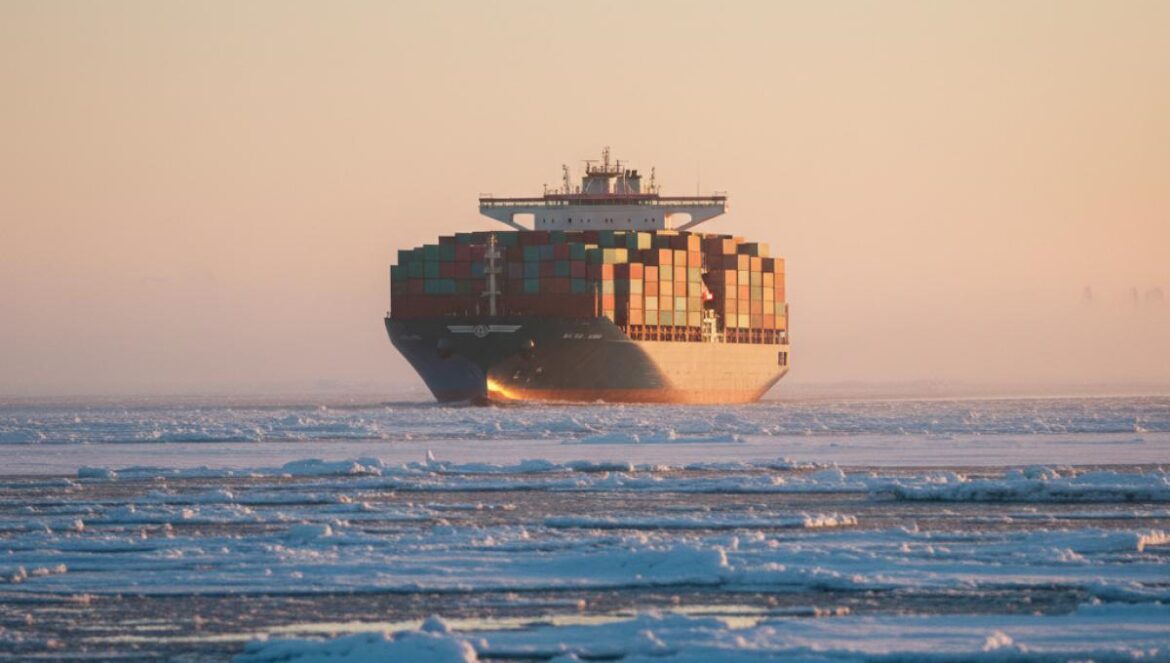 China abre ruta ártica de coches eléctricos: el atajo que reduce a la mitad tiempos y sacude el comercio Europa-Asia Portacontenedores atravesando placas de hielo fino al atardecer, con contenedores visibles y un cielo frío y dorado.