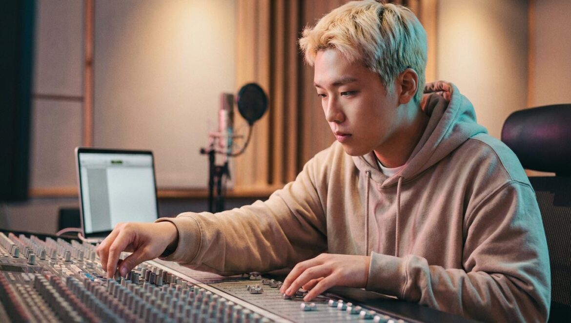 G‑Dragon y “Good Day”: la jugada creativa que cambia su regreso a la TV Productor musical coreano en un estudio, ajustando una mesa de mezclas bajo luz cálida.