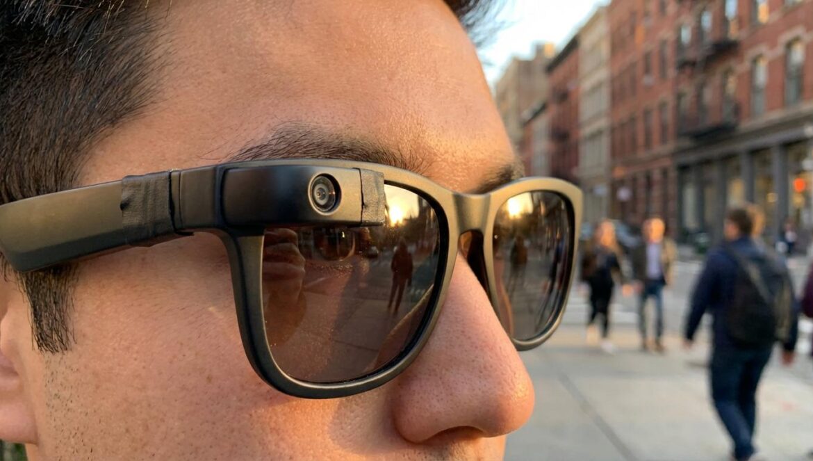 Ray-Ban Meta y privacidad: el caso que destapó lo fácil que es grabarte sin que te enteres Primer plano de unas gafas inteligentes con lente lateral y una luz tapada con cinta, en una calle concurrida al atardecer