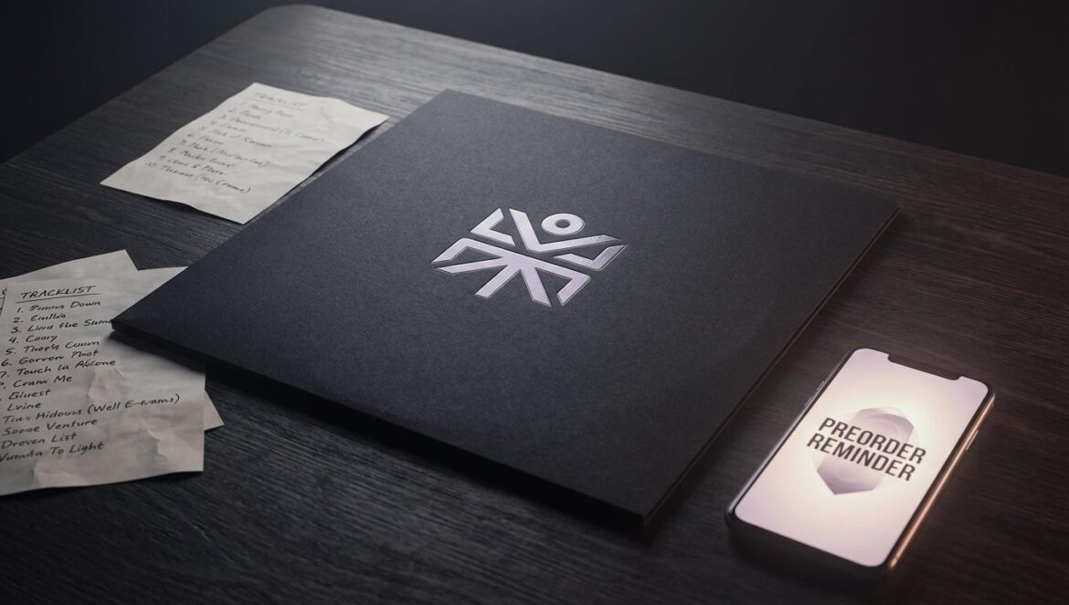 Portada minimalista de vinilo sobre mesa de estudio, con papeles de tracklist y un móvil encendido en luz tenue.