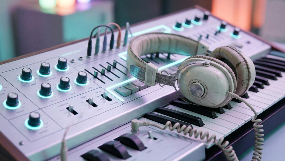 Cannelle y el electropop francés para soñadores Sintetizador analógico bajo luces de neón azul hielo con auriculares vintage, representando la estética dream-pop y DIY de la artista Cannelle.