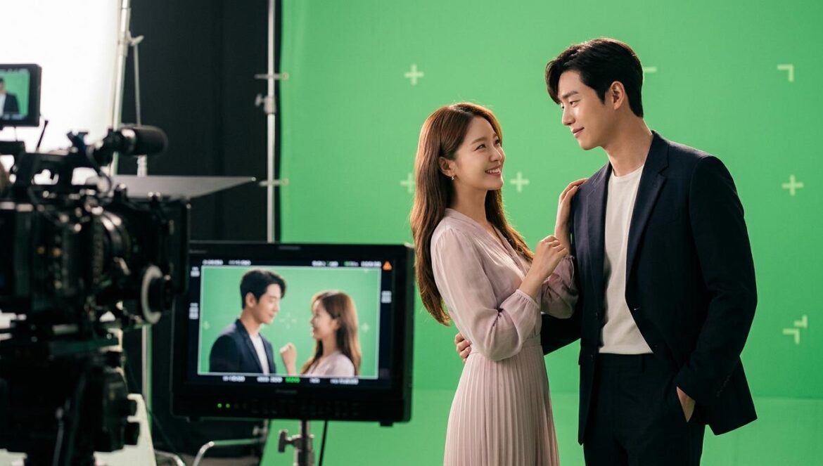 ¿Cómo se grabó Perfect Crown? IU y Byeon Woo Seok revelan todo Actores protagonistas en el set de un drama coreano rodeados de cámaras profesionales y equipos de iluminación durante una escena romántica.